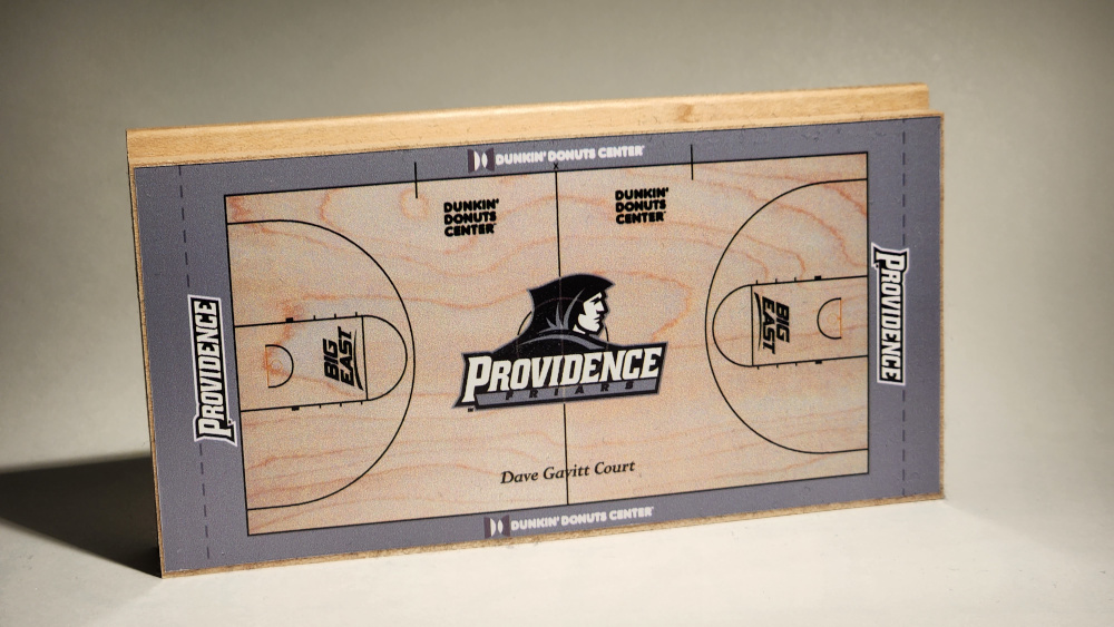 A replica of the Providence Friars basketball floor at the Dunkin Donuts Center shown on a piece of hardwood flooring by Horner Sports Flooring