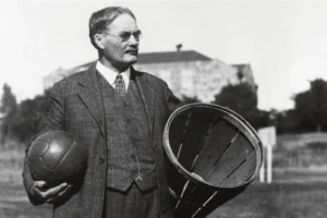 Legacy Systems - James Naismith iconic photo holding peach basket and soccer ball.