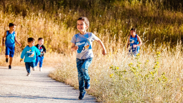 kids have fun running on a gravel path through a field